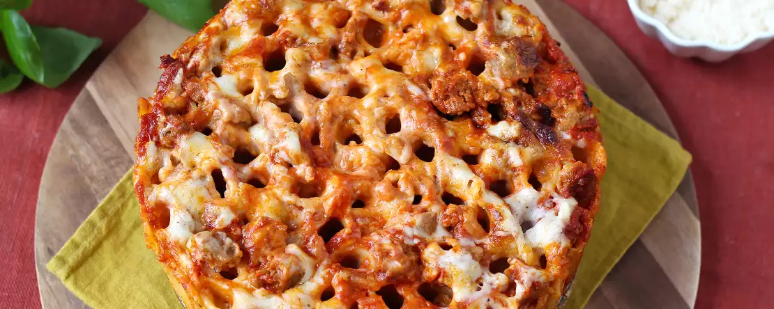 Pečený timballo z rigatoni s klobásou, bešamelem a mozzarellou